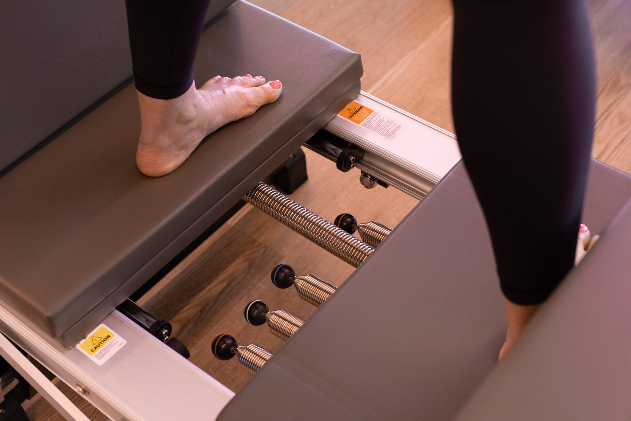 woman using pilates reformer springs