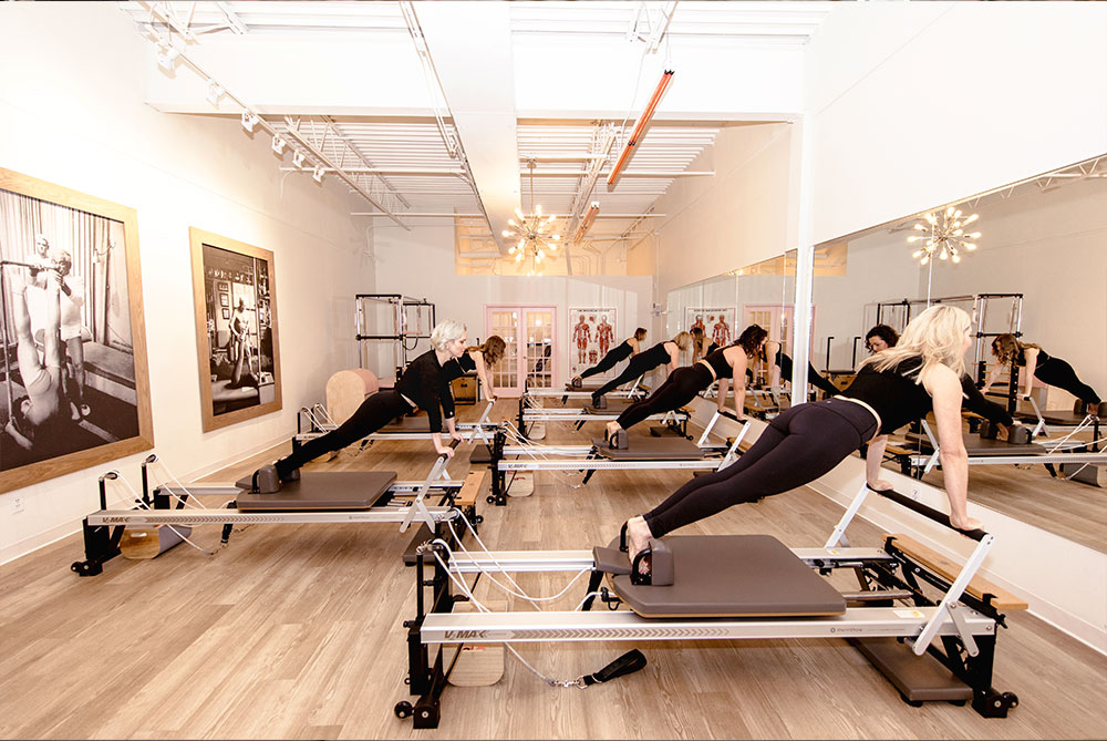 A group of students learning from their pilates instructor